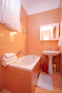 La salle de bains est pourvue d'une baignoire et d'un lavabo. dans l'établissement Apartments and rooms with parking space Makarska - 6767, à Makarska