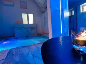 a blue room with a table and a glass at Dimora Farina Suites in Ostuni