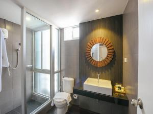a bathroom with a toilet and a sink and a mirror at Kitzio House Hotel Huai Kwang in Ban Na Song