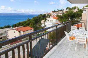 balkon ze stołem i krzesłami oraz oceanem w obiekcie Apartments with a parking space Baska Voda, Makarska - 6761 w Baskiej Vodzie