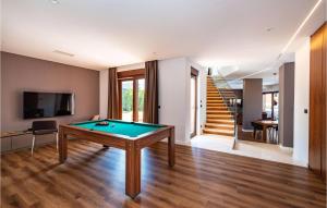 a living room with a pool table and a staircase at Beautiful Home In Novalja in Novalja