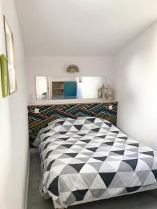 sypialnia z czarno-białym łóżkiem szachowym w obiekcie LA PETITE MAISON TAHET, 2 pers avec terrasse w mieście Basse-Indre