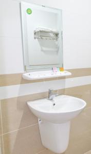 uma casa de banho com um lavatório branco e um espelho. em Ruby Hotel - Tân Uyên - Bình Dương em Hoi Nghia