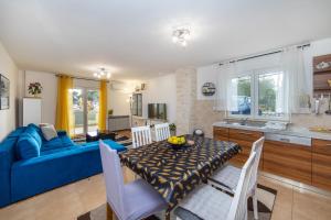 a kitchen and living room with a blue couch and a table at Apartments by the sea Podaca, Makarska - 6735 in Podaca +18 photos