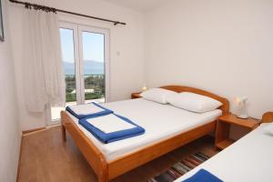 Apartments and rooms with parking space Gradac, Makarska - 6819 في غراداك: غرفة نوم عليها سرير وفوط زرقاء