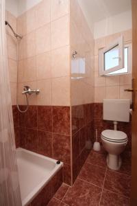 a bathroom with a tub and a toilet and a shower at Apartments and rooms with parking space Gradac, Makarska - 6819 in Gradac