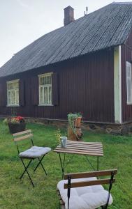 uma mesa de piquenique e duas cadeiras em frente a uma casa em Jõevaara Veskitalu 