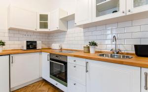 a white kitchen with white cabinets and a sink at Cozy 2 Bedroom Apartment In Terez Boulevard. in Budapest