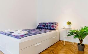 a bed in a room with a plant at Cozy 2 Bedroom Apartment In Terez Boulevard. in Budapest