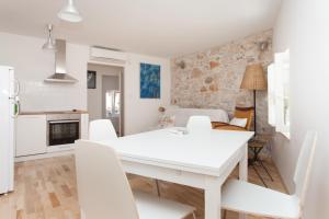 a white dining room with a white table and chairs at Apartments Rovinj Duplex in Rovinj