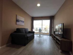 uma sala de estar com um sofá e uma televisão de ecrã plano em Apartamento en la Playa em Melenara