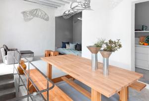 a dining room table with two vases on it at Coco-Mat Eco Residences Serifos in Vayiá