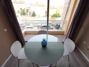 uma mesa com um vaso azul num quarto com uma janela em Apartamento en la Playa em Melenara