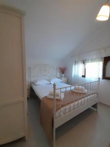 1 dormitorio con 1 cama grande con sábanas blancas en Olympian Chalet en Paralia Katerinis
