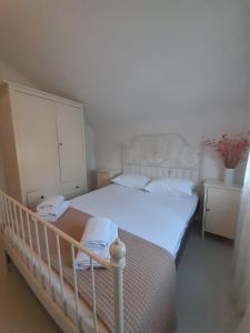 a small bedroom with a white bed and a cabinet at Olympian Chalet in Paralia Katerinis
