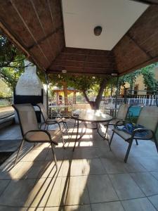a table and chairs under an umbrella on a patio at Olympian Chalet in Paralia Katerinis
