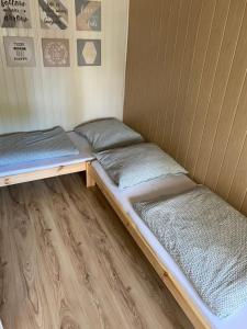 2 Betten in einem kleinen Zimmer mit Holzböden in der Unterkunft Pokoje blisko morza in Sarbinowo