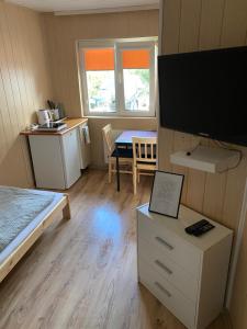 Zimmer mit einem Bett und einem Tisch mit einem TV in der Unterkunft Pokoje blisko morza in Sarbinowo
