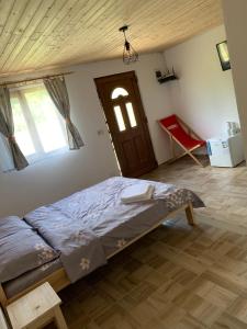 a bedroom with a bed and a wooden door at Căsuțele de vară in Vişeu de Sus