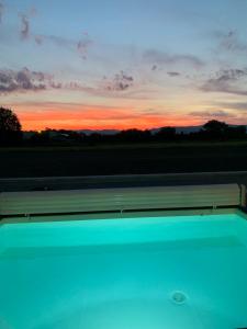 a view of a sunset from a swimming pool at CHAMBRE D'HOTES DANS MAISON PROCHE de COLMAR in Holtzwihr +5 photos