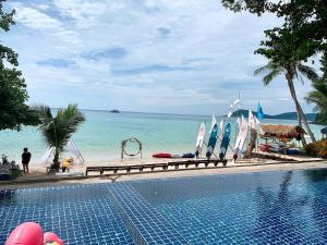 een zwembad naast een strand met de oceaan bij Kerala Coco Resort in Ko Samed