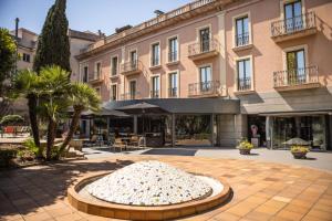 un bâtiment avec une sculpture au milieu d'une cour dans l'établissement RVHotels Spa Vila de Caldes - Adults only, à Caldes de Montbui