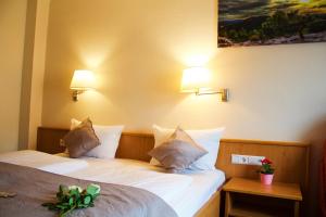 Dos camas en una habitación de hotel con dos lámparas. en Hotel Austria Stuttgart-City, en Stuttgart 46 fotos más