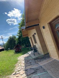 a porch of a house with a table and chairs at Căsuțele de vară in Vişeu de Sus