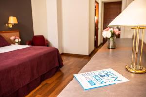 une chambre d'hôtel avec un lit et une table avec une lampe dans l'établissement RVHotels Spa Vila de Caldes - Adults only, à Caldes de Montbui