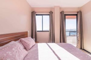 1 dormitorio con 1 cama y 2 ventanas en Apartamento con preciosas vistas al mar, en Melenara
