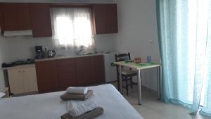 um quarto com uma cama, uma mesa e uma cozinha em Villa Tzortzaki - Dias em Térsa