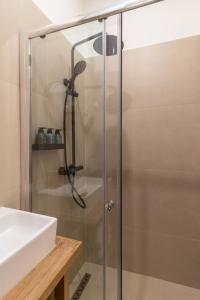 una ducha con una puerta de cristal junto a un lavabo en Vienna City Apartment, en Viena