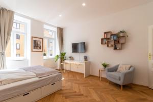 ウィーンにあるVienna City Apartmentのベッドルーム(ベッド1台、椅子、テレビ付)