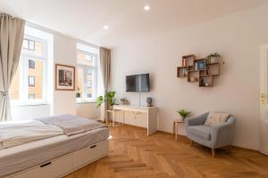 a bedroom with a bed and a chair and a tv at Vienna City Apartment in Vienna