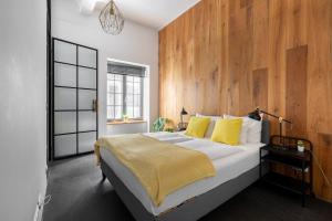 1 dormitorio con 1 cama grande y pared de madera en LOFT Astoria en Budapest