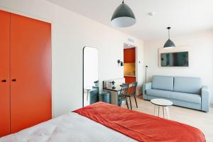 sypialnia z łóżkiem, kanapą i stołem w obiekcie Appart'City Confort Bruxelles Centre Gare du Midi w Brukseli