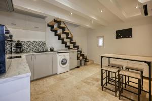 a kitchen with a washing machine and a staircase at Maison de village au cœur de Lourmarin in Lourmarin