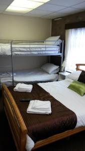 a room with three bunk beds with towels on a table at The Manuela Rose in Blackpool