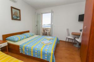 a bedroom with a bed and a table and a balcony at Apartments by the sea Drasnice, Makarska - 6697 in Drasnice