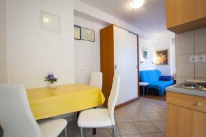 a kitchen and dining room with a yellow table and chairs at Apartments by the sea Drasnice, Makarska - 6697 in Drasnice