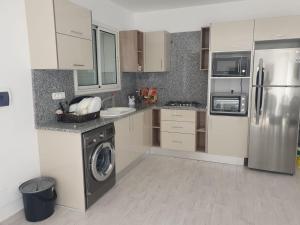 cocina con nevera de acero inoxidable y lavavajillas en Villa de luxe avec piscine sans vis à vis Midoun, en Aghīr