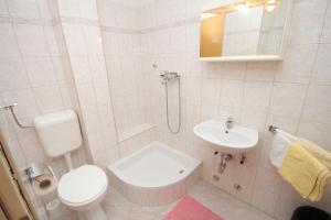 Baño blanco con aseo y lavamanos en Apartments and rooms with parking space Brela, Makarska - 6895 en Brela