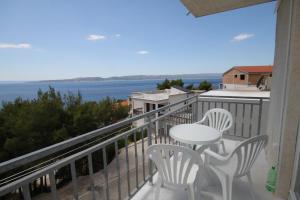 balcón con mesa, sillas y vistas al océano en Apartments and rooms with parking space Brela, Makarska - 6895 en Brela