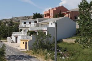 a house on the side of a street at Apartments and rooms by the sea Metajna, Pag - 6496 in Metajna