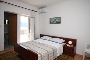 a bedroom with a bed and a large window at Apartments and rooms by the sea Metajna, Pag - 6496 in Metajna