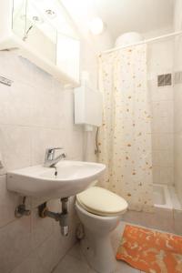 a bathroom with a sink and a toilet and a shower at Apartments and rooms by the sea Metajna, Pag - 6496 in Metajna