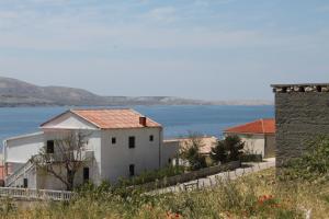 a white house with a view of the water at Rooms by the sea Metajna, Pag - 6487 in Metajna