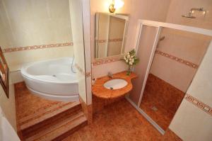 a bathroom with a tub and a toilet and a sink at Hotel Da Bruno in Venice