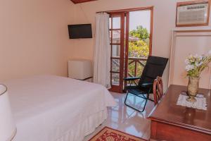 a bedroom with a bed and a table and a chair at POUSADA BLUE MOON in Búzios +76 photos