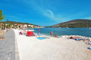 a group of people on a beach near the water at Seaside holiday house Vinisce, Trogir - 14704 in Vinišće